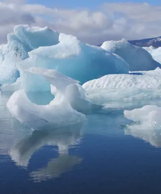 Bei einer Bootsfahrt auf dem Jökulsarlon Eisschollen vorbeischwimmen sehen